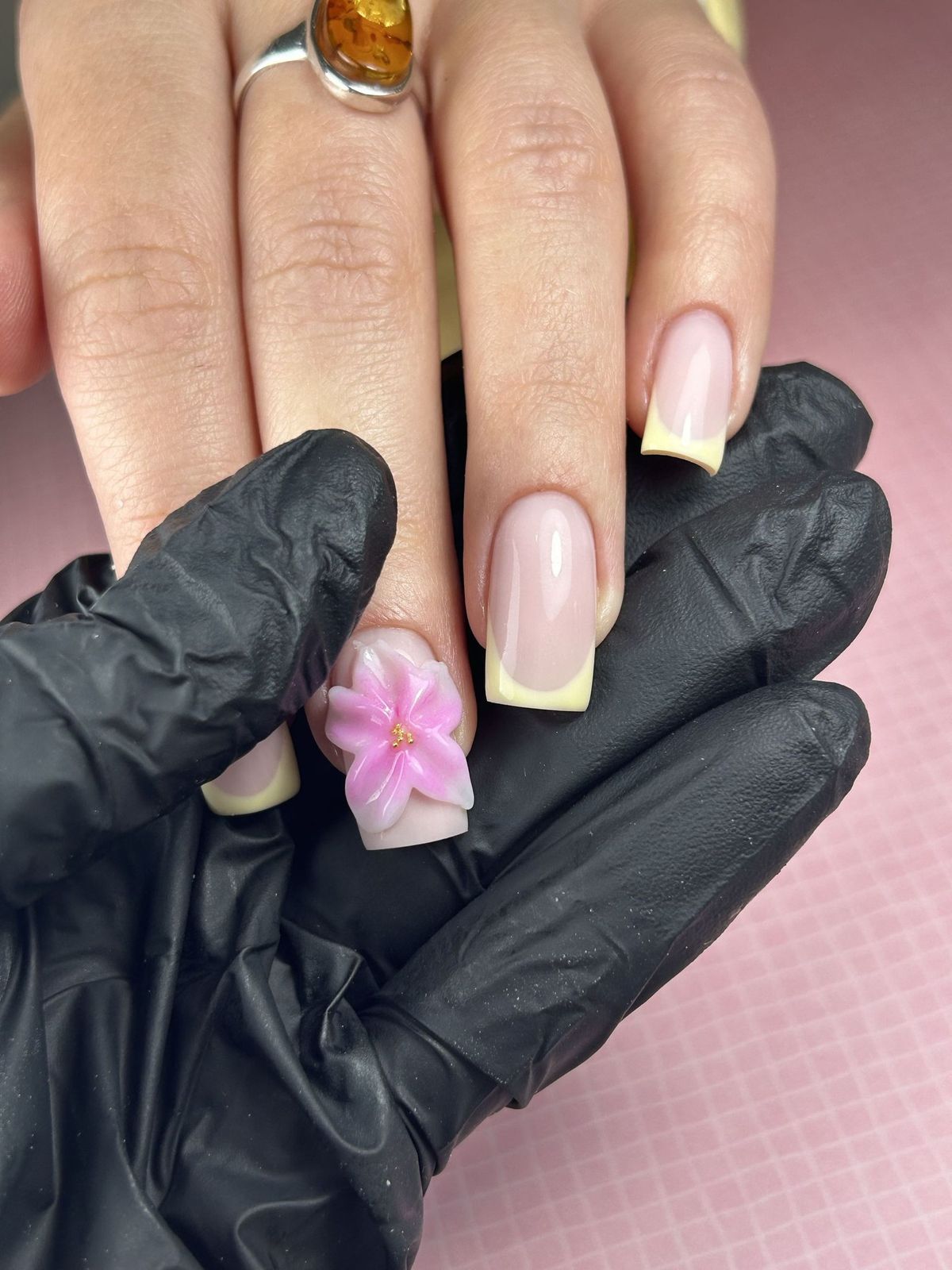 Nagel met een 3D bloem, vastgehouden door Karolina in zwarte handschoenen
