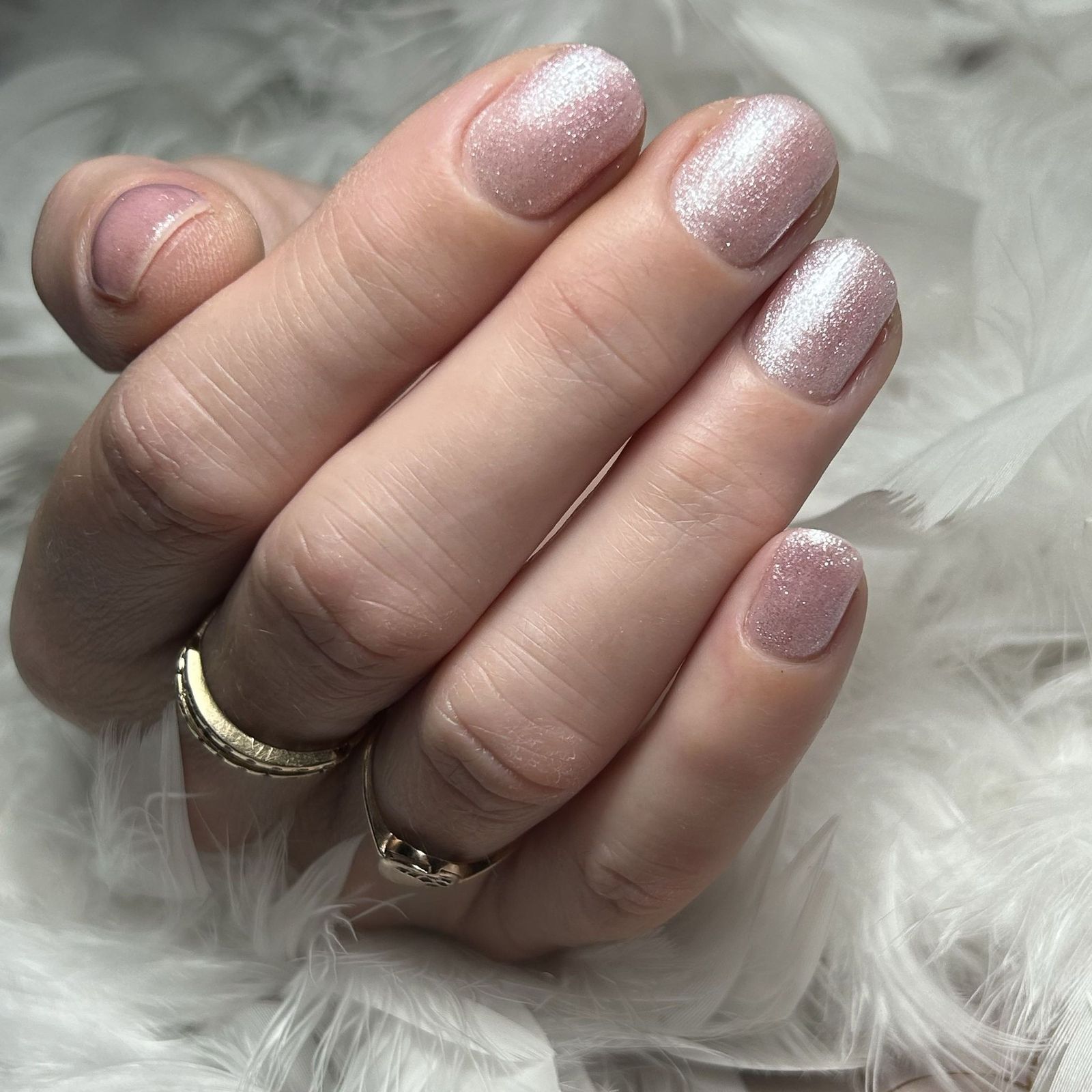 Lichte glitternagels op wit bont