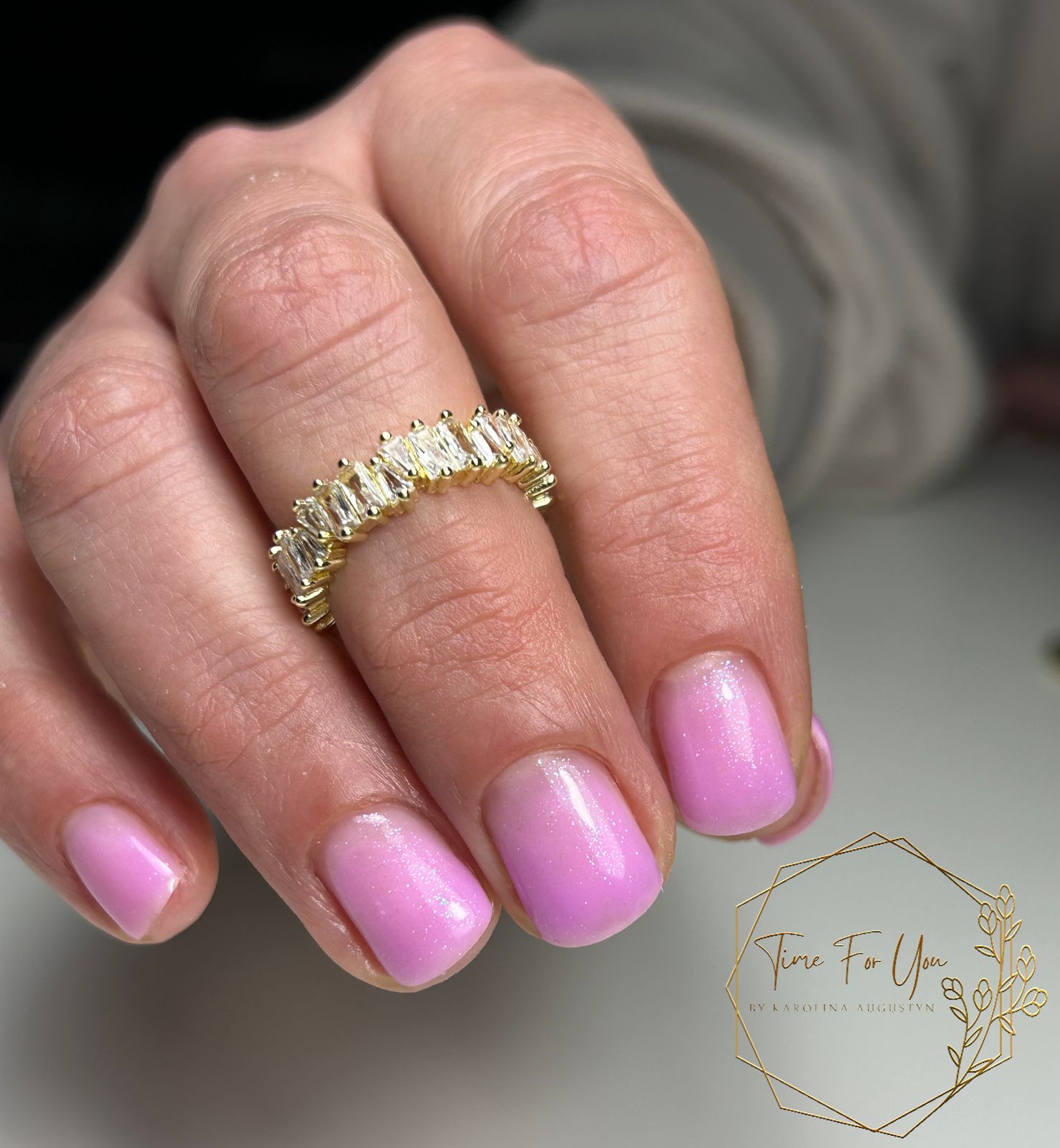Korte felroze gelnagels met een gouden ring